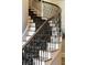 Detailed curved staircase with decorative carpet runner and wrought iron banister at 4755 Columns Se Dr, Marietta, GA 30067
