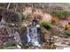Beautiful rock waterfall with lush landscaping and ambient lighting at 4755 Columns Se Dr, Marietta, GA 30067