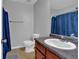Bathroom featuring a vanity with sink, toilet, and shower with a blue curtain at 2157 Capella Sw Cir, Atlanta, GA 30331