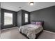 Cozy bedroom with neutral carpet, two windows, and a comfortable bed with pillows and comforter at 2157 Capella Sw Cir, Atlanta, GA 30331