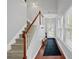 Bright entryway features a staircase with wood railing, hardwood floors, and a long runner leading to the front door at 2157 Capella Sw Cir, Atlanta, GA 30331