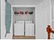 Well-lit laundry room featuring a washer, dryer, shelving, and ample storage space at 2157 Capella Sw Cir, Atlanta, GA 30331