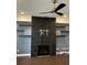 Living room featuring a black-tiled fireplace, floating shelves, and modern ceiling fan at 3208 Sonnet Se Walk, Atlanta, GA 30339