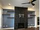 Living room featuring a black-tiled fireplace, floating shelves, and modern ceiling fan at 3208 Sonnet Se Walk, Atlanta, GA 30339