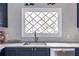 Close up of a kitchen sink, window with diamond grid, cabinets, and honeycomb backsplash at 728 Burke Rd, Atlanta, GA 30305