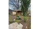 Exterior view of a home with a boarded front window surrounded by overgrown lawn and trash containers at 1771 Hosea L Williams Se Dr, Atlanta, GA 30317