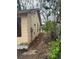 View of the side of a yellow house with boarded windows surrounded by untamed vegetation at 1771 Hosea L Williams Se Dr, Atlanta, GA 30317