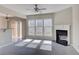 Open-concept living room with fireplace, large windows, and seamless flow to the dining area at 922 Gardenia Curv, Canton, GA 30114