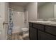 This bathroom features a shower-tub combo, granite countertops, and wood-look vinyl flooring at 11930 Guelph Cir, Hampton, GA 30228