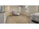 Bright bedroom with neutral carpet, chair, and natural light at 11930 Guelph Cir, Hampton, GA 30228