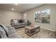Cozy living room with sofas, wood floors, and a window providing plenty of natural light at 11930 Guelph Cir, Hampton, GA 30228