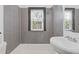 Bathroom with a clean, bright white sink and gray tile surround, complemented by natural light from a window at 2776 Grand Sw Ave, Atlanta, GA 30315