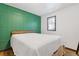 Bedroom featuring a green accent wall, bright window, and stylish wood accents at 2776 Grand Sw Ave, Atlanta, GA 30315