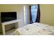 This stylish bedroom features a bed, desk, and a window with curtains overlooking the outdoors at 5586 Kingsport Dr, Atlanta, GA 30342