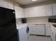 Kitchen featuring white cabinetry, black refrigerator and washer and dryer at 5586 Kingsport Dr, Atlanta, GA 30342