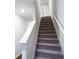 Carpeted staircase with white risers and white railing provides access to the upper level of the home at 8660 Webb Rd, Riverdale, GA 30274