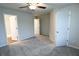 Spacious carpeted bedroom featuring neutral walls, a ceiling fan, and multiple doorways at 8662 Webb Rd, Riverdale, GA 30274