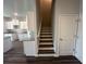 Interior view showcasing the staircase, and the open layout with the kitchen in the background at 8666 Webb Rd, Riverdale, GA 30274