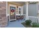 Welcoming front porch with a cozy seating area, adorned with a festive holiday wreath on the front door at 132 Cessna Dr, Canton, GA 30114