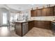 Well-lit kitchen featuring a central island, stainless steel dishwasher and dark wood cabinets with granite countertops at 132 Cessna Dr, Canton, GA 30114