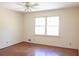 A bedroom featuring a ceiling fan and a large window for natural light, over hardwood floors at 3969 Briaridge Cir, Atlanta, GA 30340