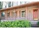 Inviting brick front porch with columns, railings, large windows, and attractive orange front door at 3969 Briaridge Cir, Atlanta, GA 30340