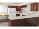 Well-lit kitchen with white appliances, wooden cabinets and white countertops and tiled floor at 3969 Briaridge Cir, Atlanta, GA 30340