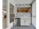 Stylish bar area with stone backsplash, modern cabinetry, and stainless steel mini refrigerator for sophisticated entertaining at 346 Carpenter Dr # 29, Atlanta, GA 30328