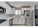 Bright kitchen with white cabinets, stainless steel appliances, tile backsplash, and window at 346 Carpenter Dr # 29, Atlanta, GA 30328