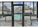 A view through the sunroom windows captures the relaxing community pool area surrounded by lush greenery at 346 Carpenter Dr # 29, Atlanta, GA 30328