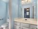 Bright bathroom with a wide mirror, white cabinetry, and a nearby toilet at 355 Highlands Trce, Roswell, GA 30075