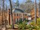 Charming two-story brick home with black shutters and a well-manicured lawn surrounded by mature trees at 355 Highlands Trce, Roswell, GA 30075