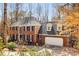 Beautiful brick home featuring an attached garage, black shutters and autumn foliage at 355 Highlands Trce, Roswell, GA 30075