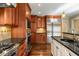 An open concept kitchen features custom wood cabinets, stainless steel appliances, and granite counters at 355 Highlands Trce, Roswell, GA 30075