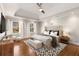 Relax in this spacious main bedroom with hardwood floors, a ceiling fan, and natural light at 355 Highlands Trce, Roswell, GA 30075