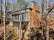 A two-story home featuring a brick chimney and sunroom overlooking a landscaped backyard at 355 Highlands Trce, Roswell, GA 30075