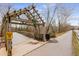 Entrance to Riverwalk featuring a covered wooden bridge with a paved path alongside at 355 Highlands Trce, Roswell, GA 30075