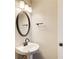 Powder room with pedestal sink, decorative mirror and lighting at 384 Minix Rd, Sharpsburg, GA 30277
