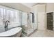 Luxurious bathroom featuring modern shower, soaking tub and view of wooded back yard at 384 Minix Rd, Sharpsburg, GA 30277