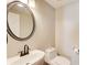 The bathroom offers a modern oval mirror over a white sink and toilet at 384 Minix Rd, Sharpsburg, GA 30277