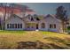 Charming white brick home with black shutters and dormer windows against a beautiful sunset sky at 384 Minix Rd, Sharpsburg, GA 30277