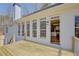 Back exterior view from a wood deck featuring a white brick facade and a door leading to the kitchen at 384 Minix Rd, Sharpsburg, GA 30277