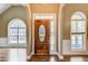 Elegant foyer with hardwood floors showcases a beautiful front door flanked by arched windows and classic trim at 384 Minix Rd, Sharpsburg, GA 30277
