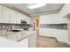Well-appointed kitchen features white cabinetry, granite countertops, and stainless steel appliances with hardwood floors at 384 Minix Rd, Sharpsburg, GA 30277