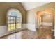 Spacious living room with a large arched window, complemented by an arched doorway leading to another well lit room at 384 Minix Rd, Sharpsburg, GA 30277