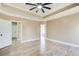 Main bedroom suite with hardwood floors, tray ceilings, ceiling fan, and multiple windows at 384 Minix Rd, Sharpsburg, GA 30277