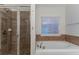 Luxurious bathroom featuring a soaking tub, glass-enclosed shower, and neutral tile finishes for a spa-like experience at 4719 Joseph Eli Dr, Snellville, GA 30039