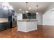 An open kitchen boasts dark cabinets, a bar-height island, stainless steel appliances, and hardwood flooring at 4719 Joseph Eli Dr, Snellville, GA 30039