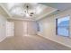 Large main bedroom with a tray ceiling, a ceiling fan, and plenty of natural light from the windows at 4719 Joseph Eli Dr, Snellville, GA 30039