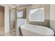 Bright bathroom featuring double sink vanity, soaking tub, and glass-enclosed shower at 124 Felicity Pike, Locust Grove, GA 30248